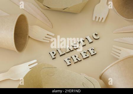KUNSTSTOFF-FREITEXT rund um umweltfreundliches, Einweg-, recycelbares, kompostierbares Geschirr. Papierkartons, Geschirr auf neutralem beigefarbenem Hintergrund. Sustainabl Stockfoto