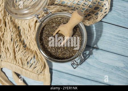 Chiasamen im Glasgefäß. Gesundes Superfood reich an Omega 3 Fettsäuren. Trockene gesunde natürliche Zutat. Chia-Körner fallen. Vegetarisches Essen Stockfoto