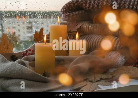 Hallo Herbst, feiern Herbstferien in gemütlichen Hause auf der Fensterbank Hygge Atmosphäre Thanksgiving Blätter, Gewürze und Kerze auf gemütlichen Strickpullover Stockfoto