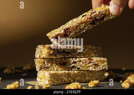 Frau nimmt hausgemachte natürliche Granola Energie-Bar. Verschiedene Protein-Müsli-Frühstücksriegel, mit Nüssen, Rosinen, getrockneten Kirschen und Schokolade. Gesund n Stockfoto