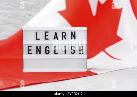 Die Nationalflagge von Kanada. Lightbox mit Text LERNE ENGLISCH Kanadische Flagge oder das Maple Leaf. Patriotismus. Konzept der internationalen Beziehungen. Unabhängig Stockfoto