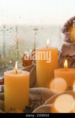 Hallo Herbst, feiern Herbstferien in gemütlichen Hause auf der Fensterbank Hygge Atmosphäre Thanksgiving Blätter, Gewürze und Kerze auf gemütlichen Strickpullover Stockfoto