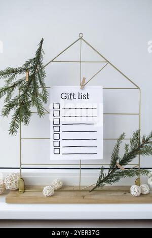 Vorbereitung auf Winterferien. Text DER GESCHENKLISTE auf Papierschein. Festgeschenke und Geschenke, die natürliche, hausgemachte Weihnachtsdekoration ohne Abfall vorbereiten. H Stockfoto