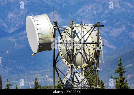 Eine Nahaufnahme und detaillierte Schuß auf der Oberseite einer Mobilfunk Basisstation, zwei kreisförmige Mikrowelle Antennen zu einem stahlgitter Turm untergebracht sind. Stockfoto