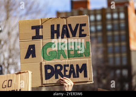 Ein Demonstrant hält ein Pappschild mit der Aufschrift „Ich habe einen grünen Traum“, aus nächster Nähe betrachtet, während sich die Menschen gegen die globale Erwärmung in einem Stadtzentrum vereinen Stockfoto