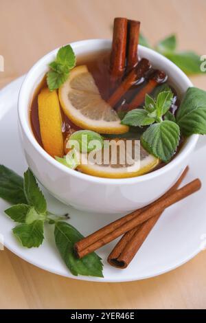 Schwarzer und grüner Tee mit Zitrone, Zimtstangen und Minzblättern. Heißes Getränk. Gesunder melissa-Tee natürliches organisches aromatisches Getränk in der Tasse. Sommer, Herbst Stockfoto