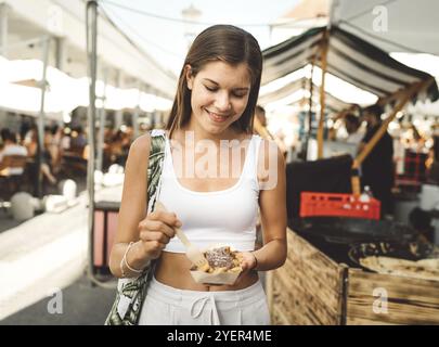 Junge kaukasische Frau, die in der Stadt Besorgungen macht, auf dem Markt shoppt, zum Mittagessen geht, durch die Stadt spaziert und eine schöne sonnige Atmosphäre genießt Stockfoto