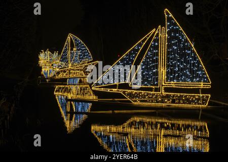 Kleine Schiffe und Boote Weihnachtsdekoration im Oliva Park Danzig Polen. Schöne Weihnachtsfeier am Abend. Adventswinterzeit in Europa bac Stockfoto