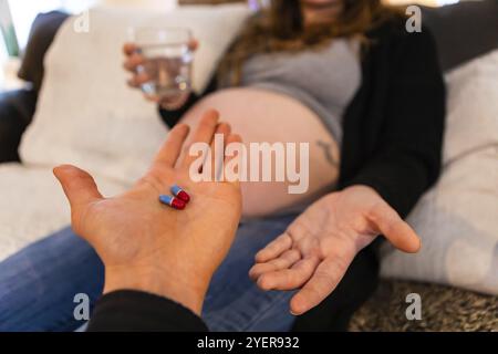 Eine erste-Person-Perspektive mit geringer Tiefenschärfe als liebevoller Vater, der sein wird, passiert schwer schwangere Partner-Schmerzmittel, während sie im Bett ruht. Kopieren Stockfoto