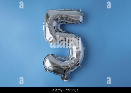 Fünf metallische Ballon isoliert auf blauem Hintergrund. Grußkarte Silberfolie Ballonnummer Happy Birthday Holiday Konzept. Kopierbereich für Text. Cel Stockfoto