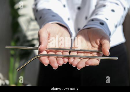 Frau mit wiederverwendbarem Metallstroh. Weibliche Hand auf wiederverwendbarem zusammenklappbarem Trinkhalm. Eco Lifestyle und Zero Waste Konzept. Kunststoff frei. Rostfrei Stockfoto