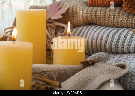 Hallo Herbst, feiern Herbstferien in gemütlichen Hause auf der Fensterbank Hygge Atmosphäre Thanksgiving Blätter, Gewürze und Kerze auf gemütlichen Strickpullover Stockfoto