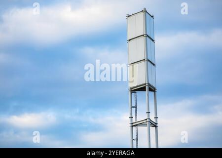 Eine niedrige Winkel Blick auf ein Funksignal Turm, hohen Stahlrahmen mit Aufstiegsleiter. Signal Rundfunk Infrastruktur gegen einen blauen Himmel mit Kopie Raum Stockfoto