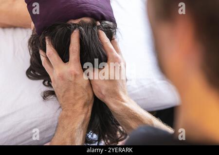 Junge Frau, die eine Kopfmassage in einer gemütlichen häuslichen Umgebung erhält. Entspannende Massagetherapie. Therapeutische Spa-Körpermassage Stockfoto