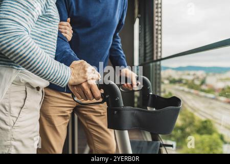 Nahaufnahme eines nicht erkennbaren Seniorenpaares, das Hände hält, während er draußen auf dem Balkon steht Stockfoto