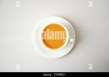 Kürbis-Smoothie, Gewürzlatte. Alkoholiger Cocktail in weißer Tasse auf weißem Hintergrund. Heiße Getränke der Herbstsaison. Erntedankfest. Draufsicht Stockfoto