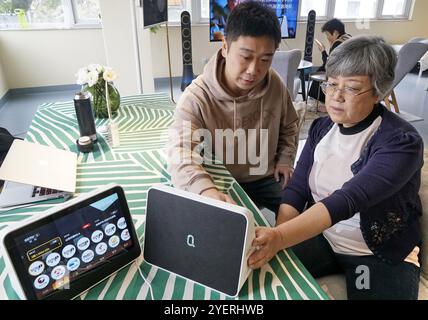 (241101) -- PEKING, 1. November 2024 (Xinhua) -- Ein Mitarbeiter eines Seniorenpflegezentrums führt eine Seniorin bei der Nutzung intelligenter Geräte im Bezirk Dongcheng in Peking, Hauptstadt von China, am 31. Oktober 2024. Peking ist in eine gemäßigte alternde Gesellschaft eingedrungen: Die permanente ältere Bevölkerung in der Stadt erreichte Ende 2023 4,95 Millionen, was 22,6 Prozent der gesamten permanenten Bevölkerung der Stadt ausmacht, so das kommunale Zivilbüro. Die Stadt hat ein gemeindenahes Pflegedienstmodell entwickelt und plant, 100 Seniorenpflegezentren im Unterbezirk zu errichten Stockfoto