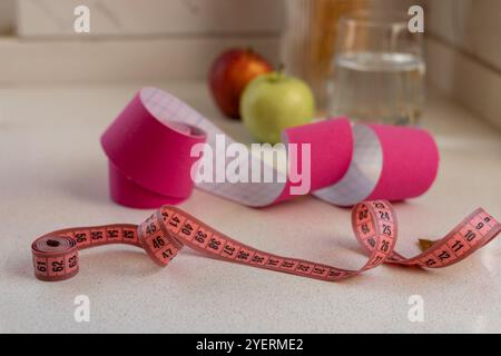 Pinkfarbenes kinesio-Klebeband mit einem Maßband auf weißem Hintergrund Stockfoto