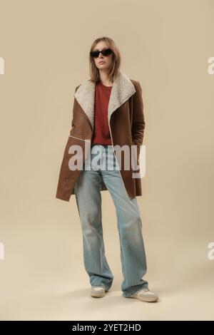 Serie von Studiofotos von Frauen im klassischen Herbst-Winter-Outfit – blaue Jeans und Winterjacke aus Schafsleder Stockfoto