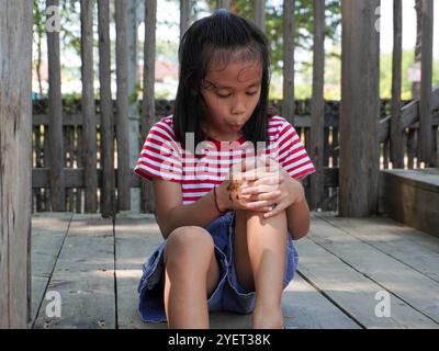 Ein junges Mädchen hat sich beim Spielen auf einem Spielplatz das Knie verletzt. Das verletzte Knie des Kindes. Stockfoto