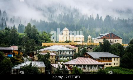 Blick auf die Kirche im Nebel, Mestia, Georgia. St. Nikolaus Kirche in Mestia Stockfoto