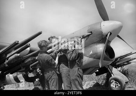 Die Bodenbesatzung in Bazenville, Normandie, Frankreich, bewaffnete einen Hawker Typhoon, einen britischen einsitzigen Jagdbomber, der als Ersatz für den Hawker Hurricane gedacht war, aber diese Anforderung nie vollständig erfüllte. Sie etablierte sich in Rollen wie Nachteindringling und Langstreckenjäger. Ab Ende 1943 wurden RP-3-Raketen in die Panzerung aufgenommen. Mit diesen Waffen und den vier 20 mm Hispano Autokanonen wurde der Taifun zu einem der erfolgreichsten Bodenangriffsflugzeuge des Zweiten Weltkriegs. Stockfoto