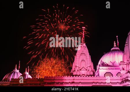 London, Großbritannien. 31. Oktober 2024. Die Feierlichkeiten schließen mit einem Feuerwerk ab, das hier mit dem leuchtend beleuchteten Tempel im Vordergrund zu sehen ist. Diwali, das Hindu Festival der Lichter, wird im BAPS Shri Swaminarayan Mandir gefeiert, im Volksmund als Neasden-Tempel bekannt, mit einem kostenlosen Festival mit traditionellen Zeremonien, Gottesdiensten und Familienaktivitäten. Der wunderschöne traditionelle Hindusteintempel ist einer der größten außerhalb Indiens gebaut. Quelle: Imageplotter/Alamy Live News Stockfoto