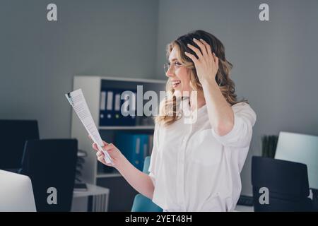 Foto der attraktiven jungen Frau staunte Papierkram Vertragsbekleidung formalwear komfortable moderne Bürozimmer innen Arbeitsplatz Stockfoto