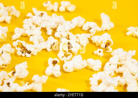 Nahaufnahme von Popcorn, verstreut auf einem gelben Kino-Food-Konzept Stockfoto