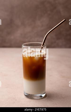 Kaffee mit Kokosmilch und Eiswürfeln in einem hohen Glas. Traditionelles alkoholfreies kaltes Getränk. Selektiver Fokus, Nahaufnahme. Stockfoto