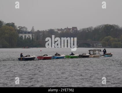 Hamburg, Deutschland. November 2024. Segelboote werden bei bewölktem Herbstwetter von einem Motorboot über die Außenalster gezogen. Quelle: Marcus Brandt/dpa/Alamy Live News Stockfoto