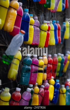 Farbenfrohe Auswahl an Getränkeflaschen vor schwarzem Hintergrund mit verschiedenen Farbtönen und Arrangements in einer urbanen Umgebung Stockfoto