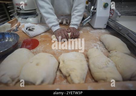 Hamburg, Deutschland. November 2024. Ein Mitarbeiter kntet den Teig für Schmalzkuchen an einem Stand auf dem Wandsbeker Winterzauber Weihnachtsmarkt. Quelle: Marcus Brandt/dpa/Alamy Live News Stockfoto