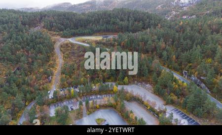 Blick aus der Vogelperspektive auf ein bewaldetes Gebiet mit gewundenen Straßen und Parkplätzen, umgeben von dichten Bäumen und Hügeln. Stockfoto