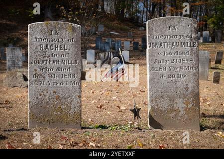 Grabsteine für Ehemann und Ehefrau aus dem 19. Jahrhundert und eine amerikanische Flagge auf dem Old Bedford Cemetery, auch bekannt als Old Burying Ground. In Bedford, Westchester, New York. Stockfoto