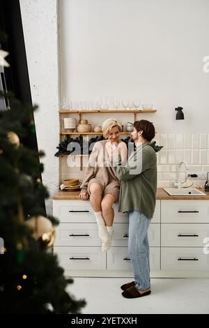 Ein Paar teilt einen freudigen Moment in ihrer gemütlichen Küche, strahlt Wärme und Zuneigung aus. Stockfoto