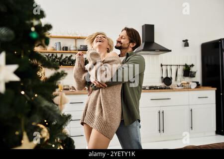 Ein Paar teilt Wärme und Lachen, während es sich in einer gemütlichen Urlaubsküche umgibt. Stockfoto