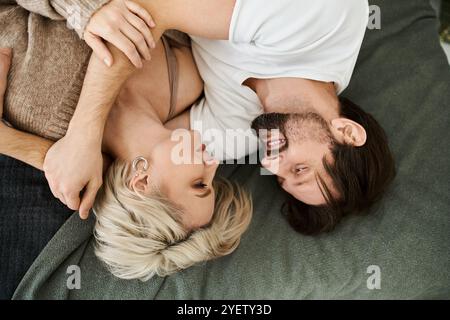 Ein Paar lacht zärtlich, während es sich auf einer bequemen Couch umgibt und Wärme ausstrahlt. Stockfoto