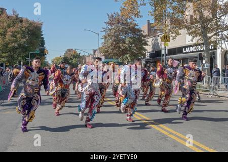 Männer der bolivianischen Tanzgruppe von San Simon marschieren auf der 37th Avenue in Jackson Heights, Queens, New York, in sehr farbenfroher Kostüme Stockfoto