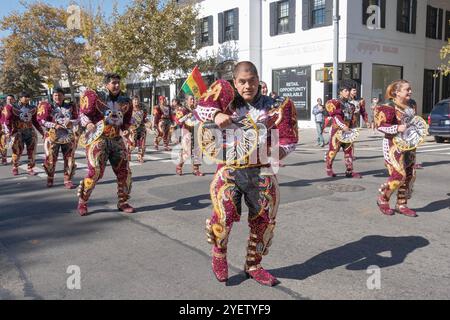 Männer der bolivianischen Tanzgruppe von San Simon marschieren auf der 37th Avenue in Jackson Heights, Queens, New York, in sehr farbenfroher Kostüme Stockfoto