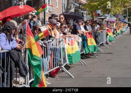 Die Zuschauer der Bolivianischen Tagesparade 2024 zeigen stolz bolivianische Flaggen. In Jackson Heights, Queens, New York. Stockfoto