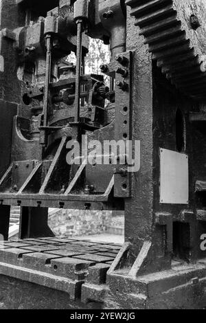 Doppelkurbel drücken. Massive schwarze Getriebe und andere Teile von Vintage-Industriemaschinen, Nahaufnahme Schwarzweiß-Foto mit selektivem Fokus, schwere Indu Stockfoto