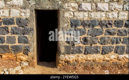 Eine Öffnung in einer alten Backsteinmauer, wahrscheinlich aus einem Abschnitt eines Hauses im Stil einer antiken Konstruktion Stockfoto