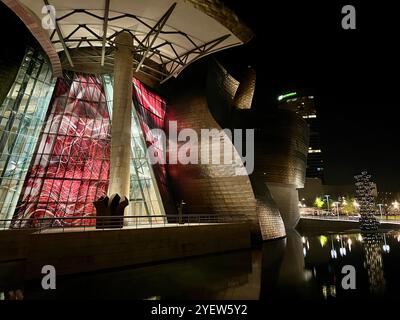 Guggenheim Museum in Bilbao Spanien. Nächtliche Fotos des Museums beleuchtet in roten und weißen Lichtern. Das Museum wurde von Frank Gehry entworfen. 20. Jahrhundert Stockfoto