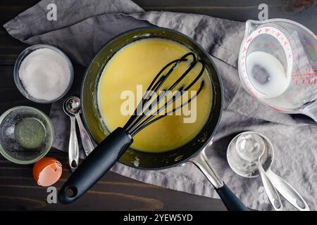 Topf mit frisch zubereitetem Tangzhong Roux: Wasser-Roux in einer Soße, umgeben von Zutaten und Küchenausstattung Stockfoto