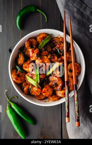 Schüssel Tom Rim (vietnamesische karamelisierte Garnelen): Südostasiatische Meeresfrüchte mit dicker Sauce, grünen Zwiebeln, Chili-Paprika und Essstäbchen Stockfoto