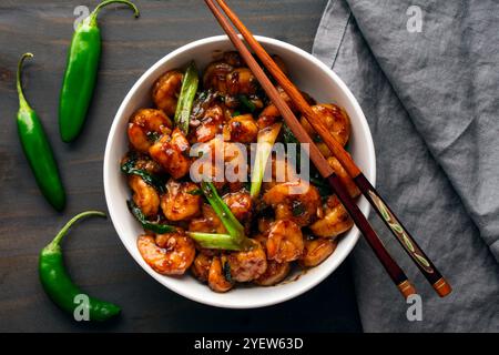 Schüssel Tom Rim (vietnamesische karamelisierte Garnelen): Südostasiatische Meeresfrüchte mit dicker Sauce, grünen Zwiebeln, Chili-Paprika und Essstäbchen Stockfoto