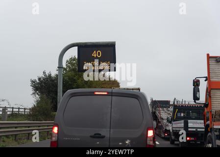 Stau auf der Autobahn M11, verursacht durch einen Autounfall in der Nähe von Harlow, Essex, Großbritannien. Matrixschild mit 40, Verkehr für Unfallmeldung gehalten Stockfoto