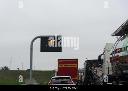 Stau auf der Autobahn M11, verursacht durch einen Autounfall in der Nähe von Harlow, Essex, Großbritannien. Schild „Linke Spur geschlossen“ Stockfoto