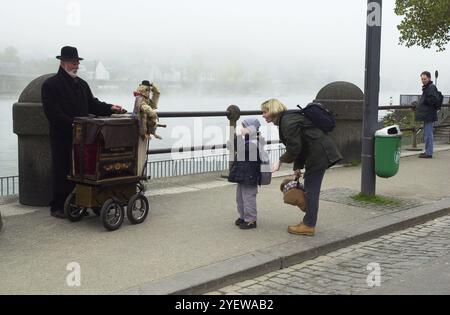 Straßenorgel oder Fassorgelanimateurin am Deutschen Eck in Koblenz Deutschland Musik Mann und Kind. Deutsche Entertainer Unterhaltung Straßen Mann alte Kinder europa european Deutschland Stockfoto